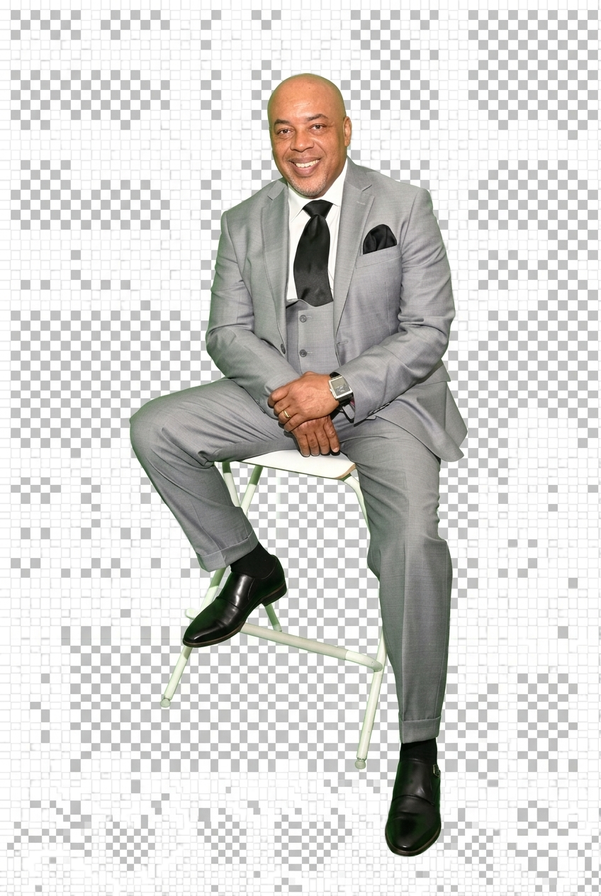 Roderick Coleman seated, smiling, in a gray three-piece suit